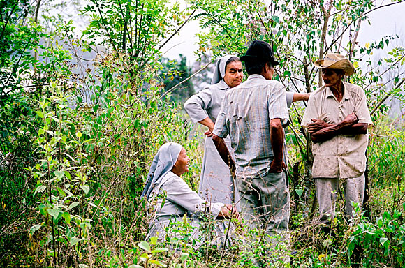 photograph of nuns and community members talking in a field